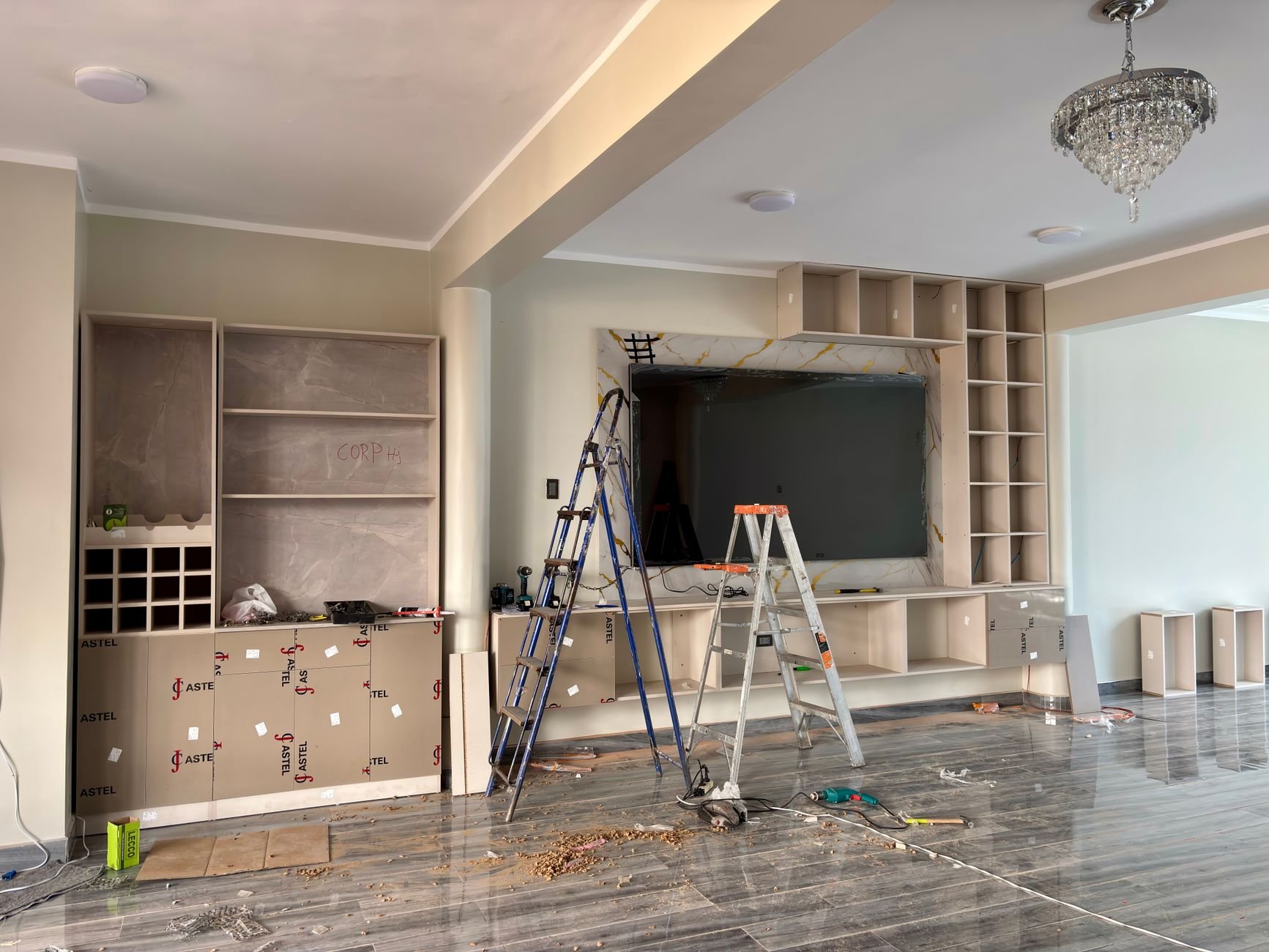 Interior renovation scene with ladders and tools in a modern living room.